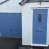 White house with matching blue front door and garage door