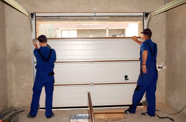 contractors repairing a damaged garage door